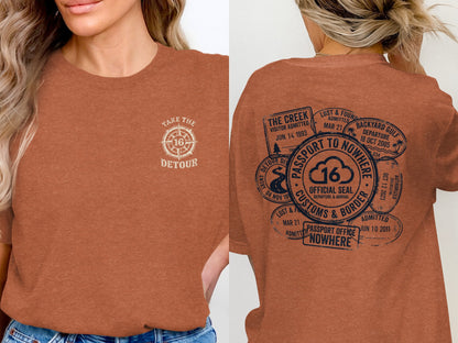 Orange t-shirt with "Take the Detour" graphic and passport-themed stamp details.