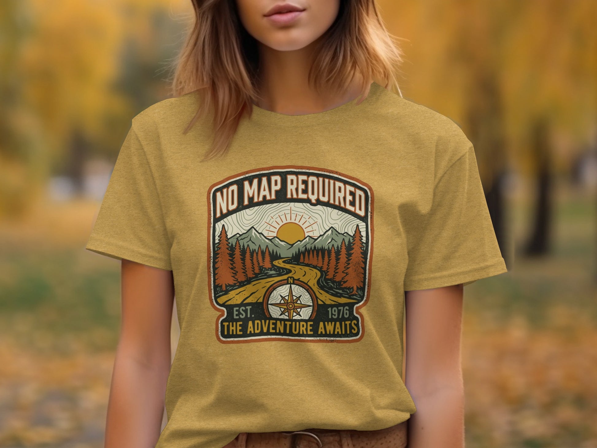 Heritage No Map Required: The Adventure Awaits Nomad Tee: Mustard t-shirt with a circular emblem featuring a compass, mountains, and "No Map Required The Adventure Awaits" text.