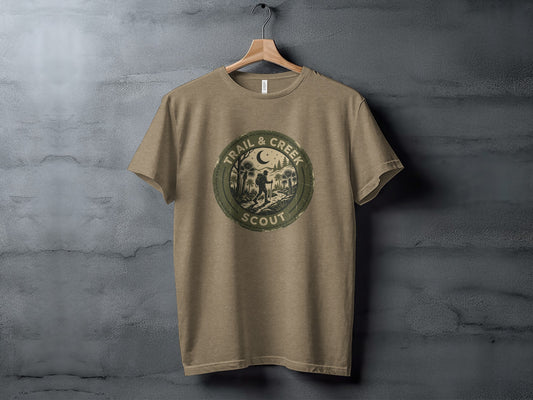Heritage Trail & Creek Scout Adventure Nomad Tee: Tan t-shirt with round "Trail & Creek Scout" logo featuring a nighttime camping scene.