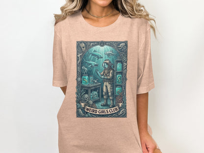 Diver in aquarium surrounded by sea life and text "WEIRD GIRLS CLUB".