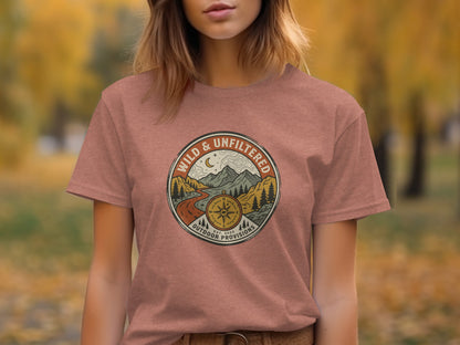 Rugged Wild & Unfiltered Explorer Wilderness Shirt: Brown t-shirt with a circular patch logo featuring mountains, a road, and compass.