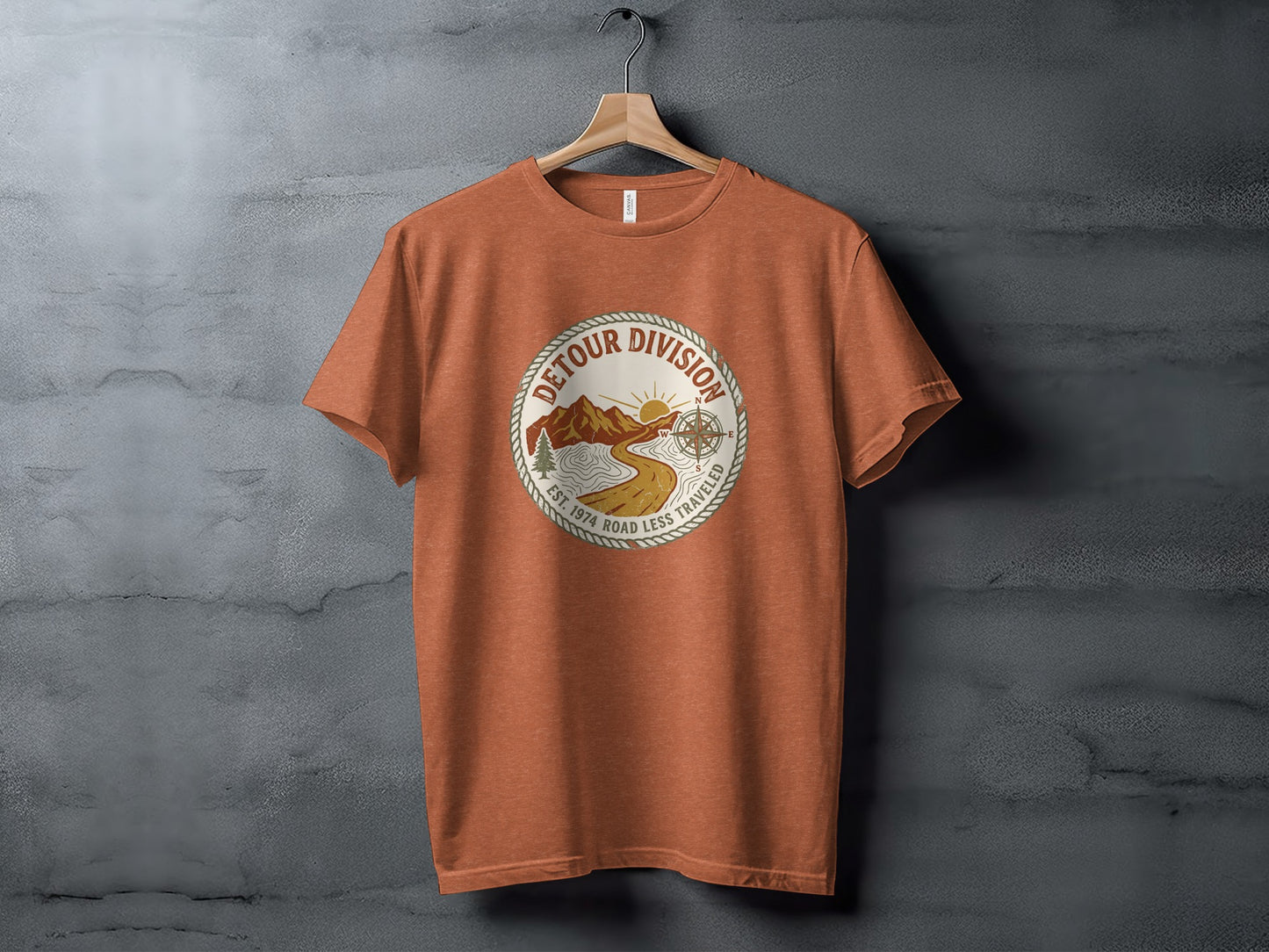 Detour Division Heritage | Vintage Outdoor Apparel: Orange t-shirt with circular "Detour Division" graphic featuring mountains, road, and compass.