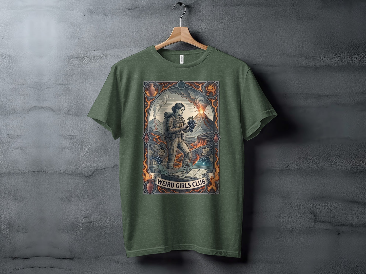 T-shirt with illustration of a woman near a volcano, holding fruit, text "Weird Girls Club."