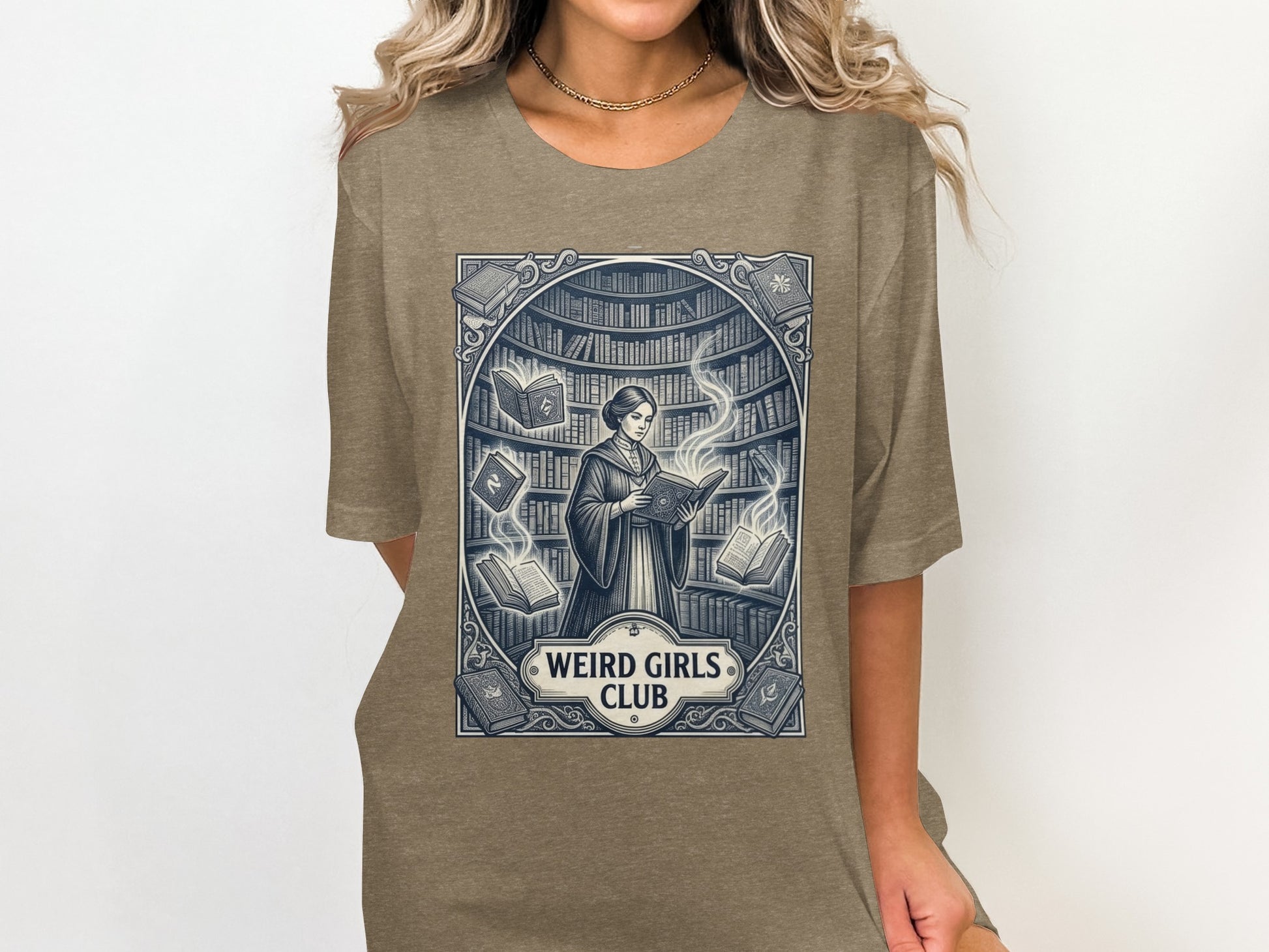 T-shirt graphic of a woman reading in a library with "Weird Girls Club" text.