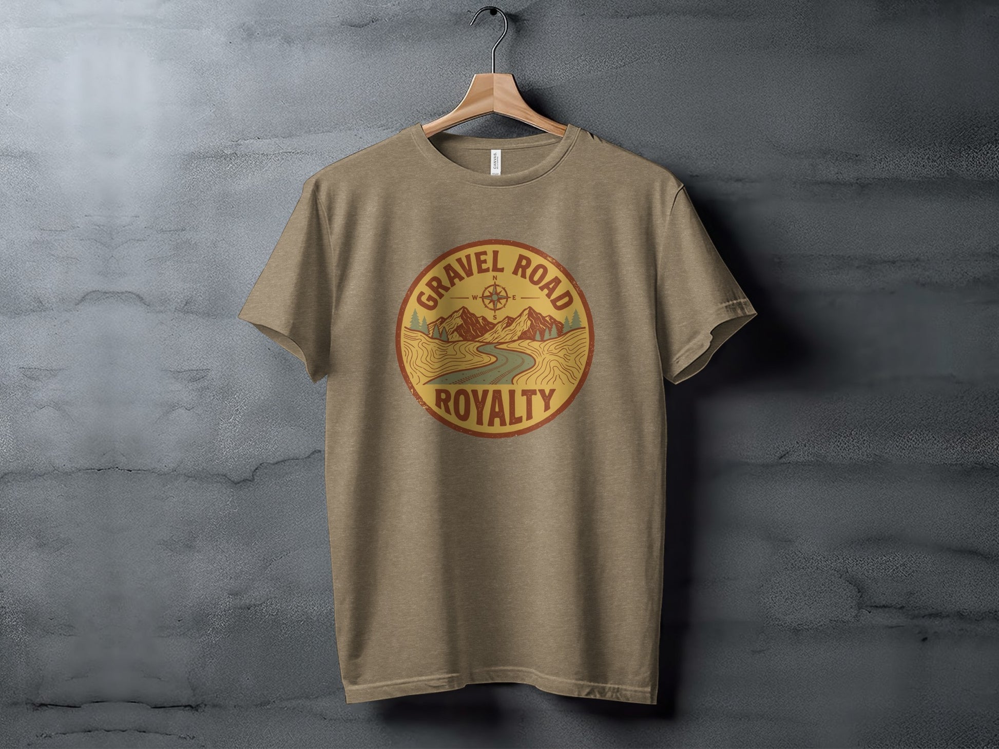 Gravel Road Royalty Adventure Tee | Vintage Outdoor Apparel: Tan t-shirt featuring a circular graphic with "Gravel Road Royalty" text and a mountain landscape.