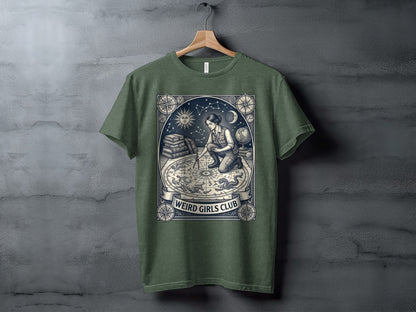 T-shirt with celestial map and kneeling woman, "Weird Girls Club" text.