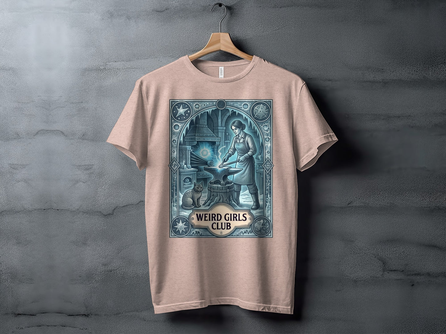 T-shirt with a graphic of a woman blacksmith and cat, "Weird Girls Club" text.