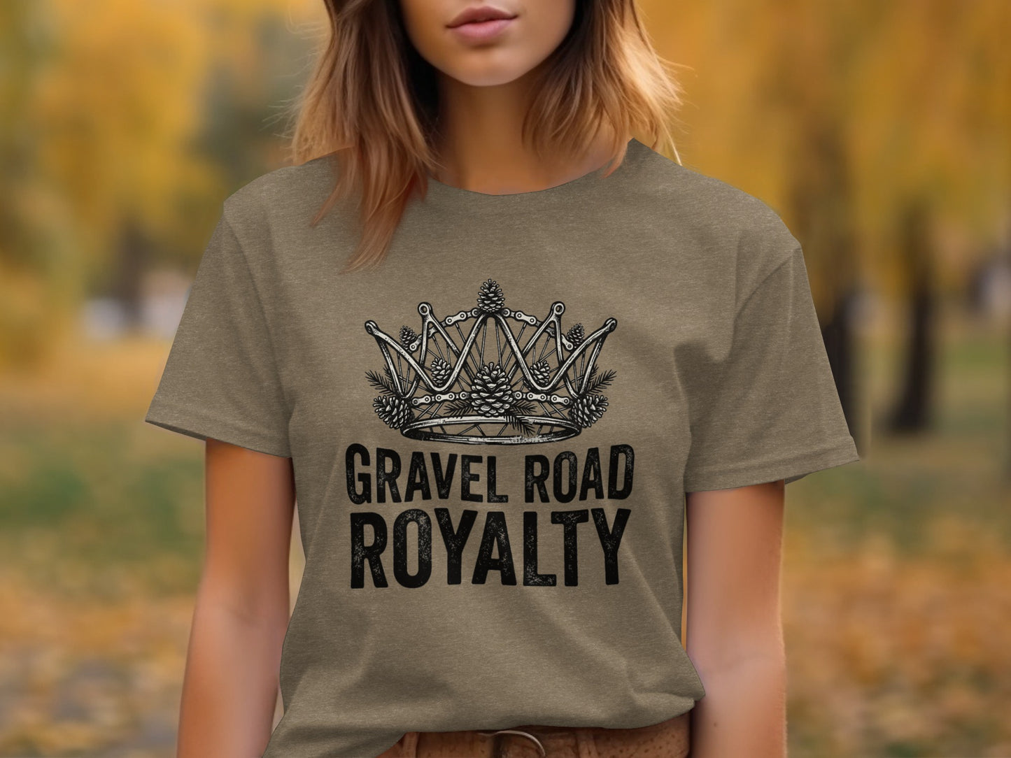 Gravel Road Royalty: Backcountry Outpost Shirt: Brown t-shirt with a crown graphic made of bicycle gears and pinecones, text reads "GRAVEL ROAD ROYALTY".