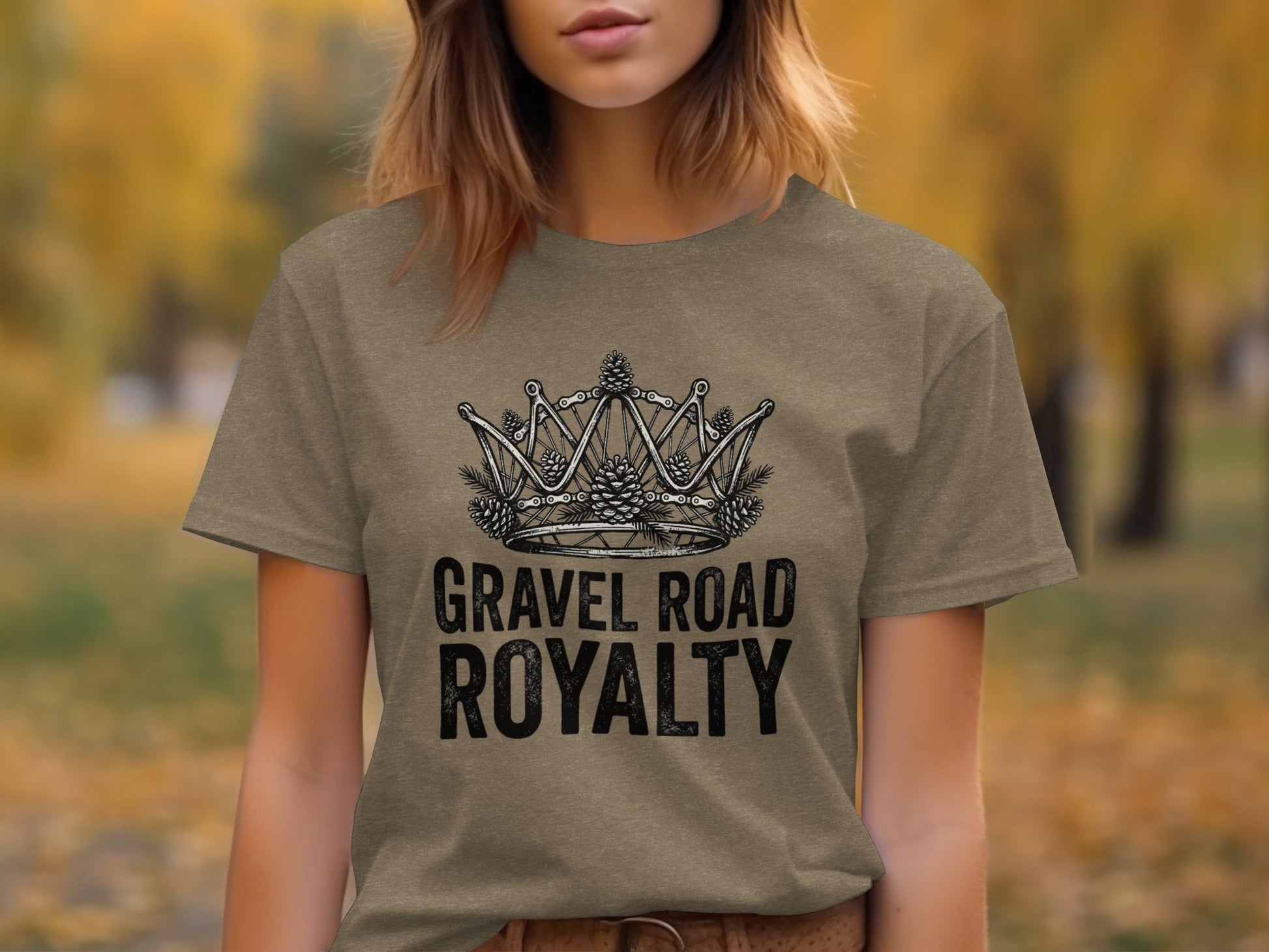 Gravel Road Royalty: Backcountry Outpost Shirt: Brown t-shirt with a crown graphic made of bicycle gears and pinecones, text reads "GRAVEL ROAD ROYALTY".