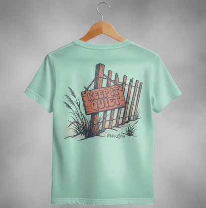 Pale blue t-shirt with a wooden fence and "Keep It Quiet" sign graphic.