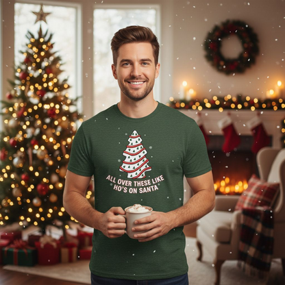 Man wearing a green t-shirt with a Christmas tree design and text, holding a mug in a festive room.