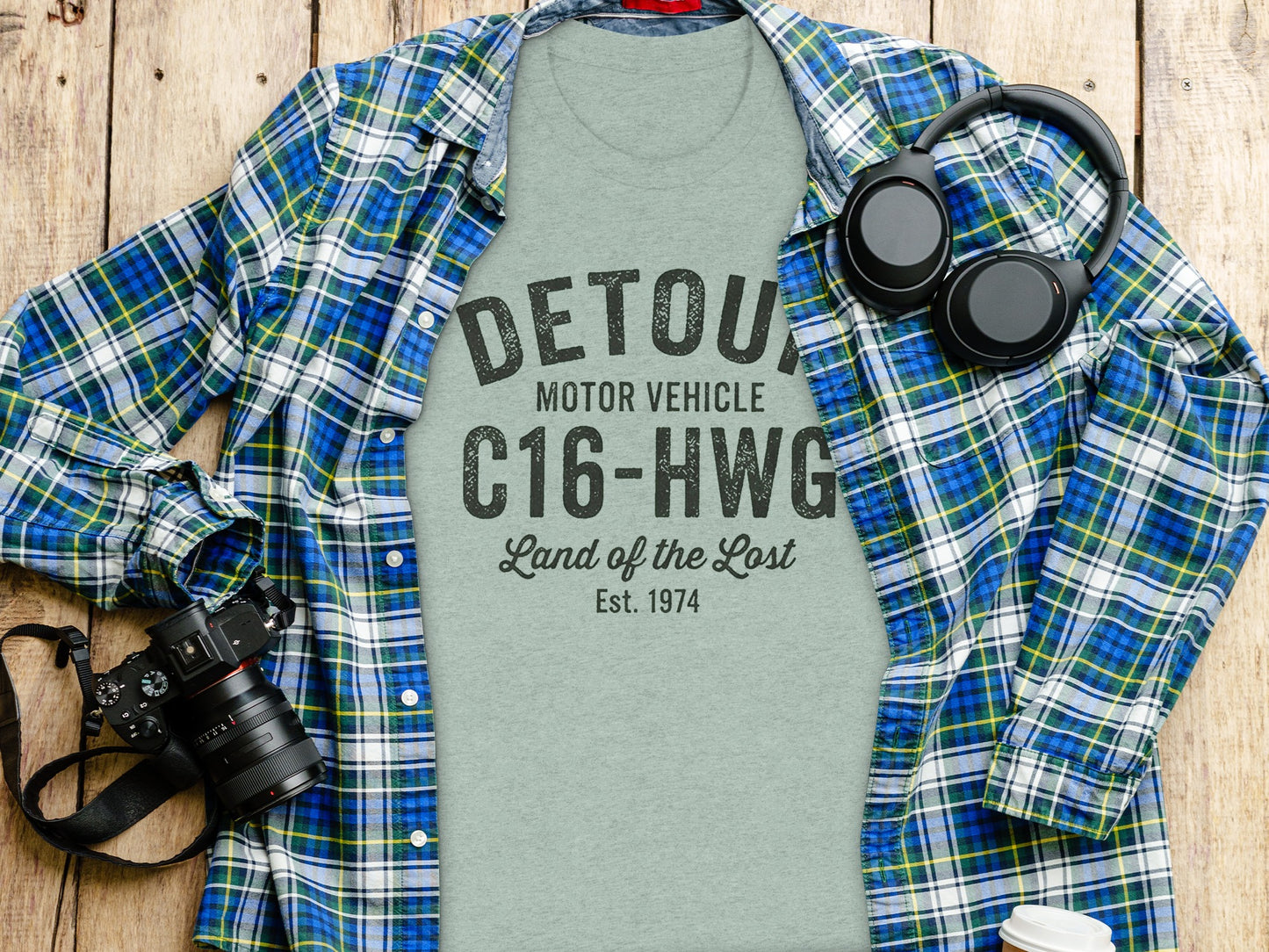 Gray t-shirt with "DETOUR MOTOR-VEHICLE Land of the Lost Est. 1974" text.