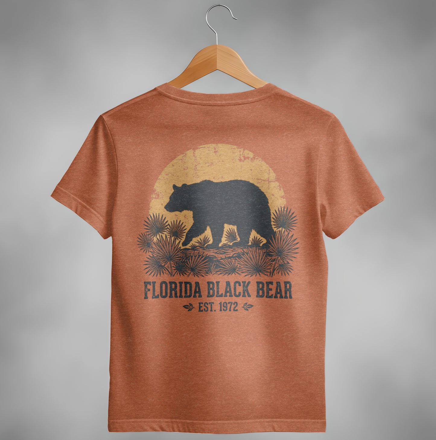 Florida Black Bear graphic on orange t-shirt, walking towards a setting sun.
