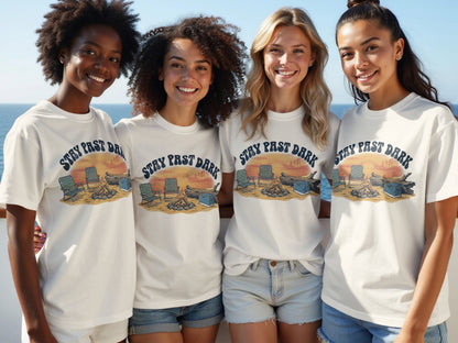 Four young women wearing white t-shirts with "STAY PAST DARK" and campfire graphic.