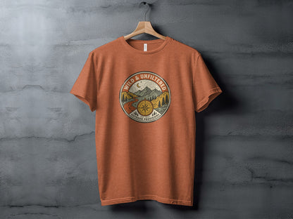 Rugged Wild & Unfiltered Explorer Wilderness Shirt: Orange t-shirt with circular "Wild & Unfiltered" logo featuring a compass and mountain scene.