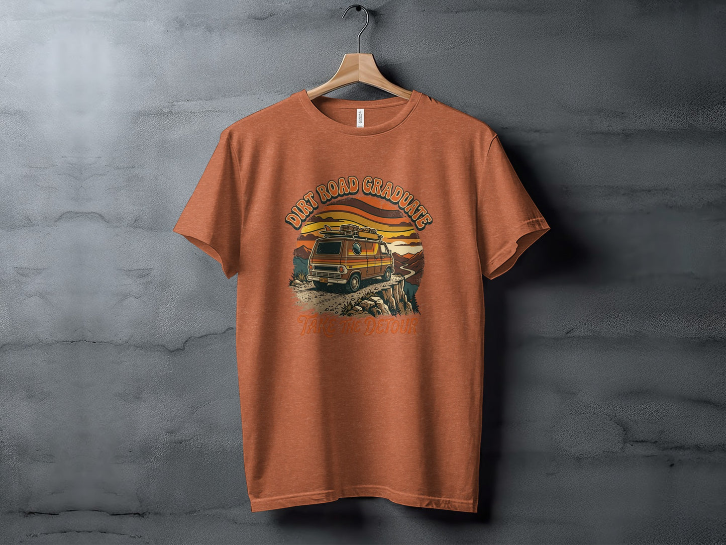 Heritage Dirt Road Graduate Adventure Tee Nomad Tee: Orange t-shirt with "Dirt Road Graduate Take The Detour" graphic of a van and sunset.