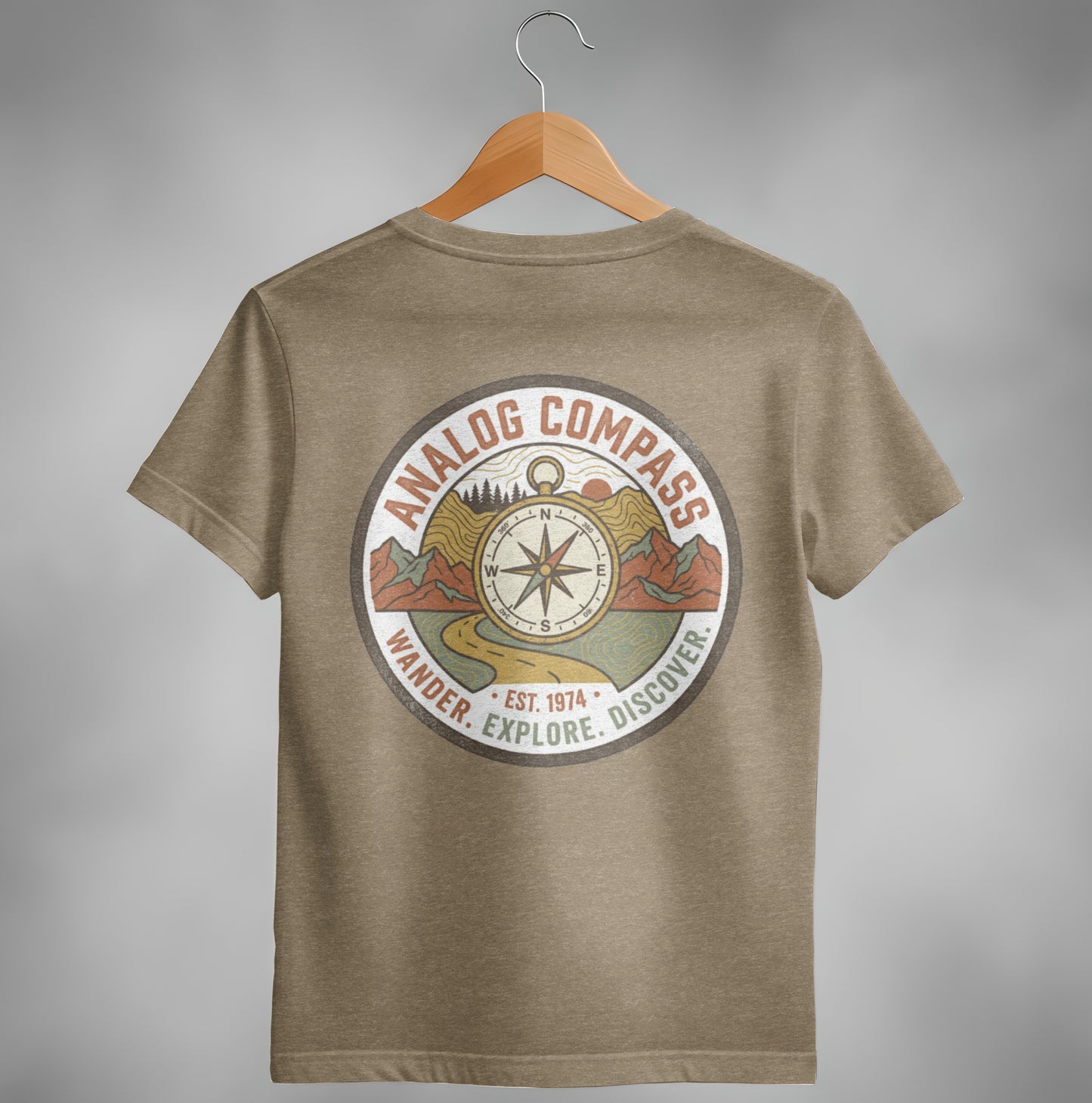 Brown t-shirt with circular "Analog Compass" logo featuring mountains, road, and compass.