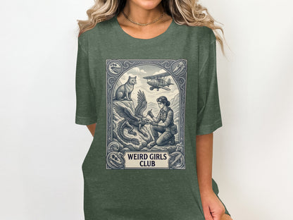 T-shirt with "Weird Girls Club" text and vintage-style dragon, aviator, and cat illustration.