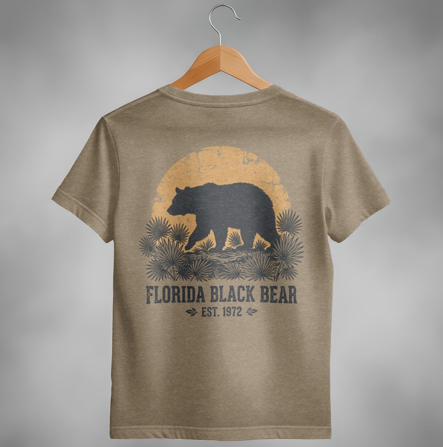 Brown t-shirt with a black bear silhouette against a sunset and palm fronds.