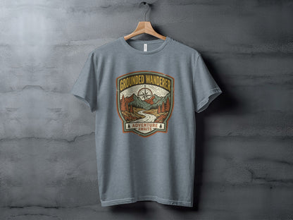 Heritage Grounded Wanderer Adventure Nomad Tee: Gray t-shirt with "Grounded Wanderer Adventure Awaits" mountain landscape graphic.