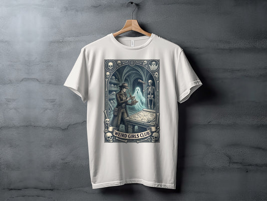 White t-shirt with "Weird Girls Club" text and a gothic-themed illustration.