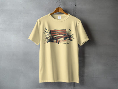 Light yellow t-shirt with a sketch of a wooden bench among beach grass.