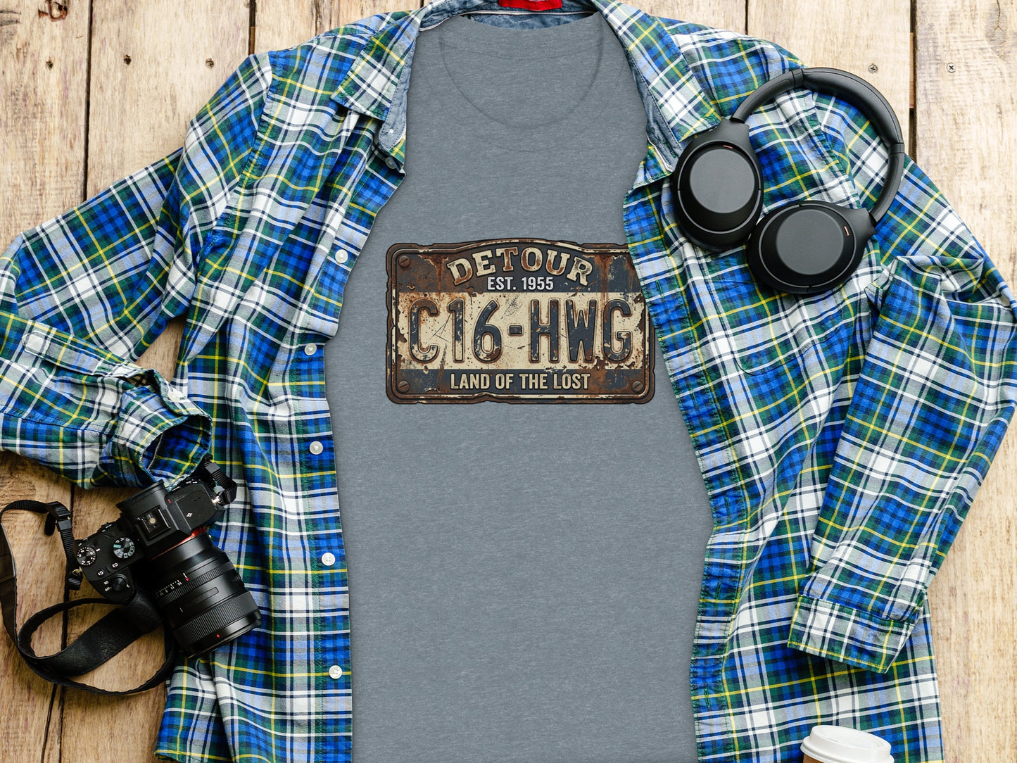 Land of the Lost Detour Plate: The Explorer's Adventure Tee: Gray t-shirt with "DETOUR C16-HWG LAND OF THE LOST" graphic, headphones, and camera.