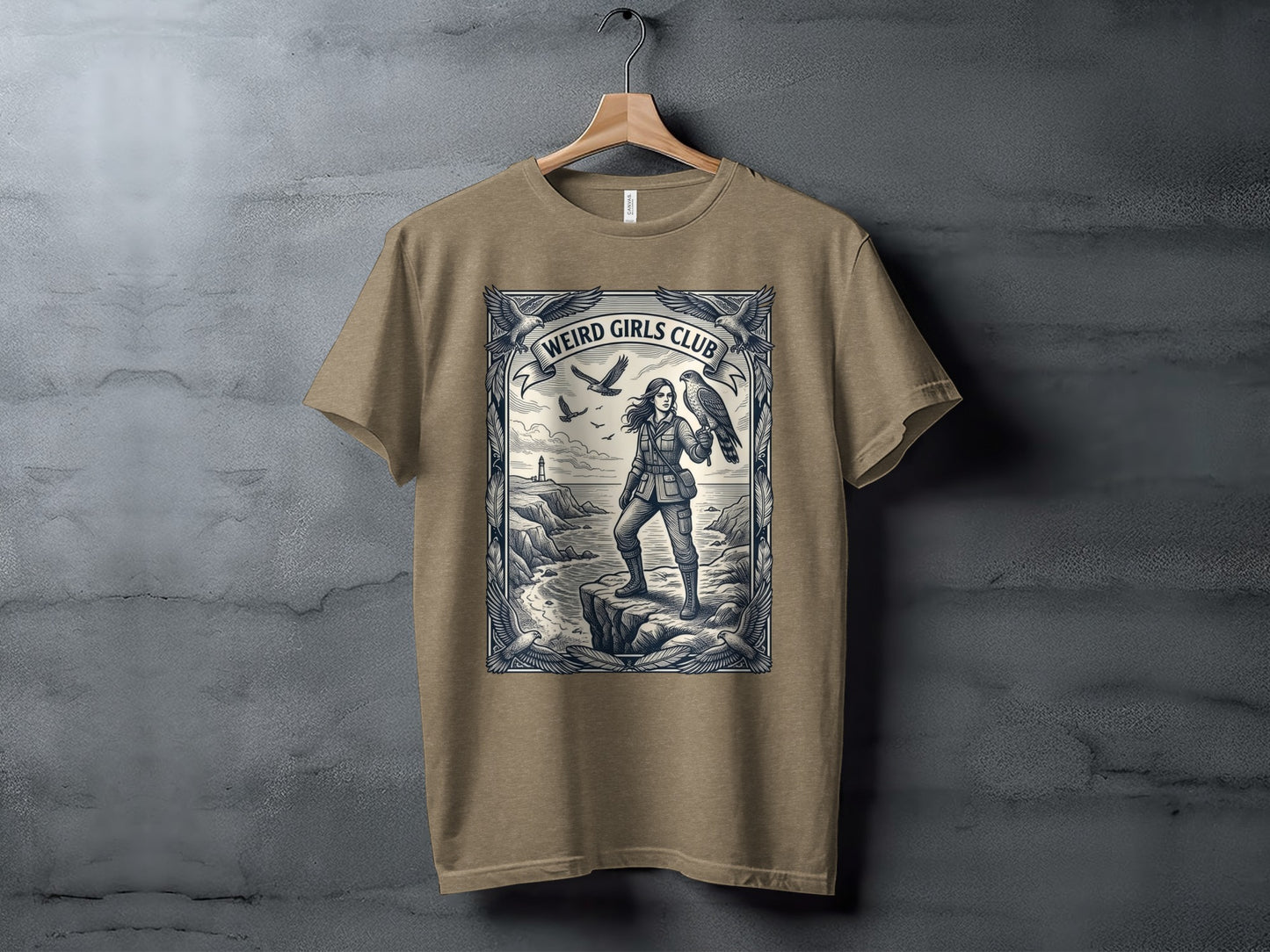 T-shirt featuring a woman with a falcon by the sea, "Weird Girls Club" text above.