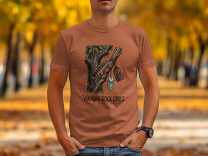 Heritage Walking Stick Spirit: Journey Nomad Tee: T-shirt graphic: feather, stone, and tag hanging from tree branch.