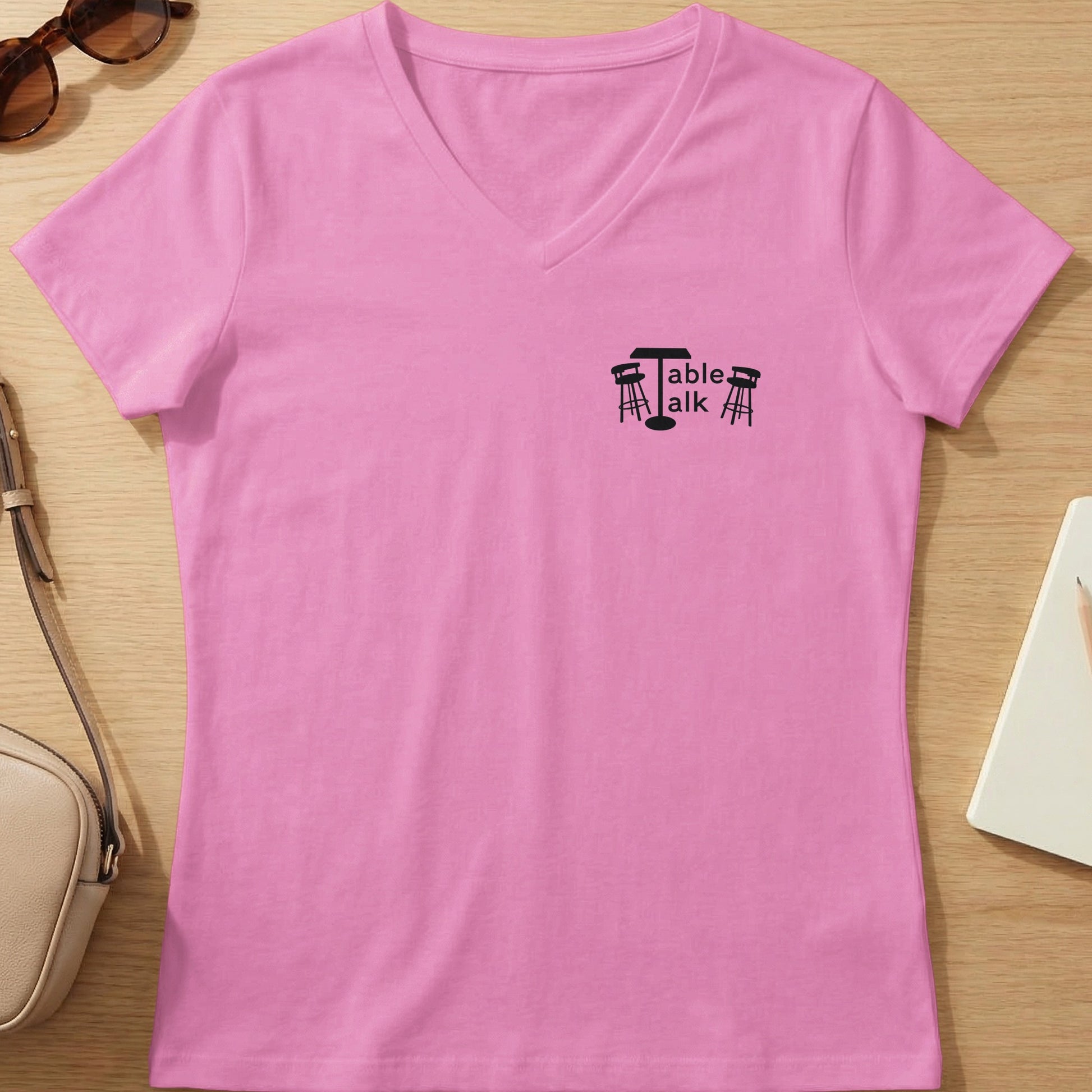 Pink v-neck t-shirt with "Table Talk" text and stool graphic.