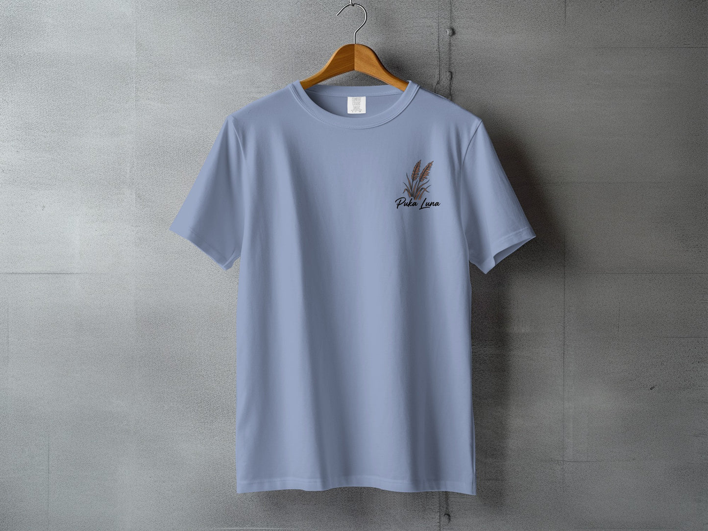 Light blue t-shirt with a small brown floral design and "Perla Luna" text.