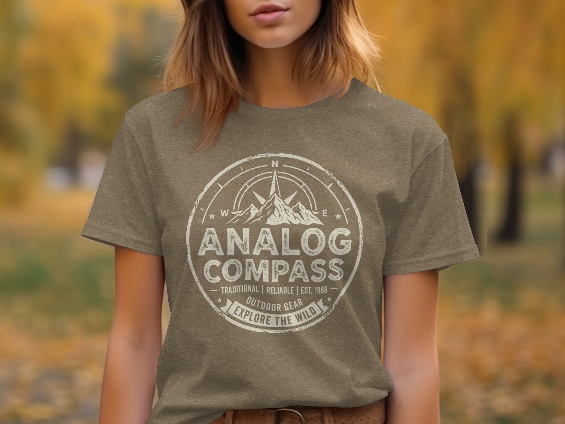 Analog Compass Heritage: The Explorer's Adventure Tee: Brown t-shirt with "Analog Compass Outdoor Gear Explore the Wild" text and compass design.