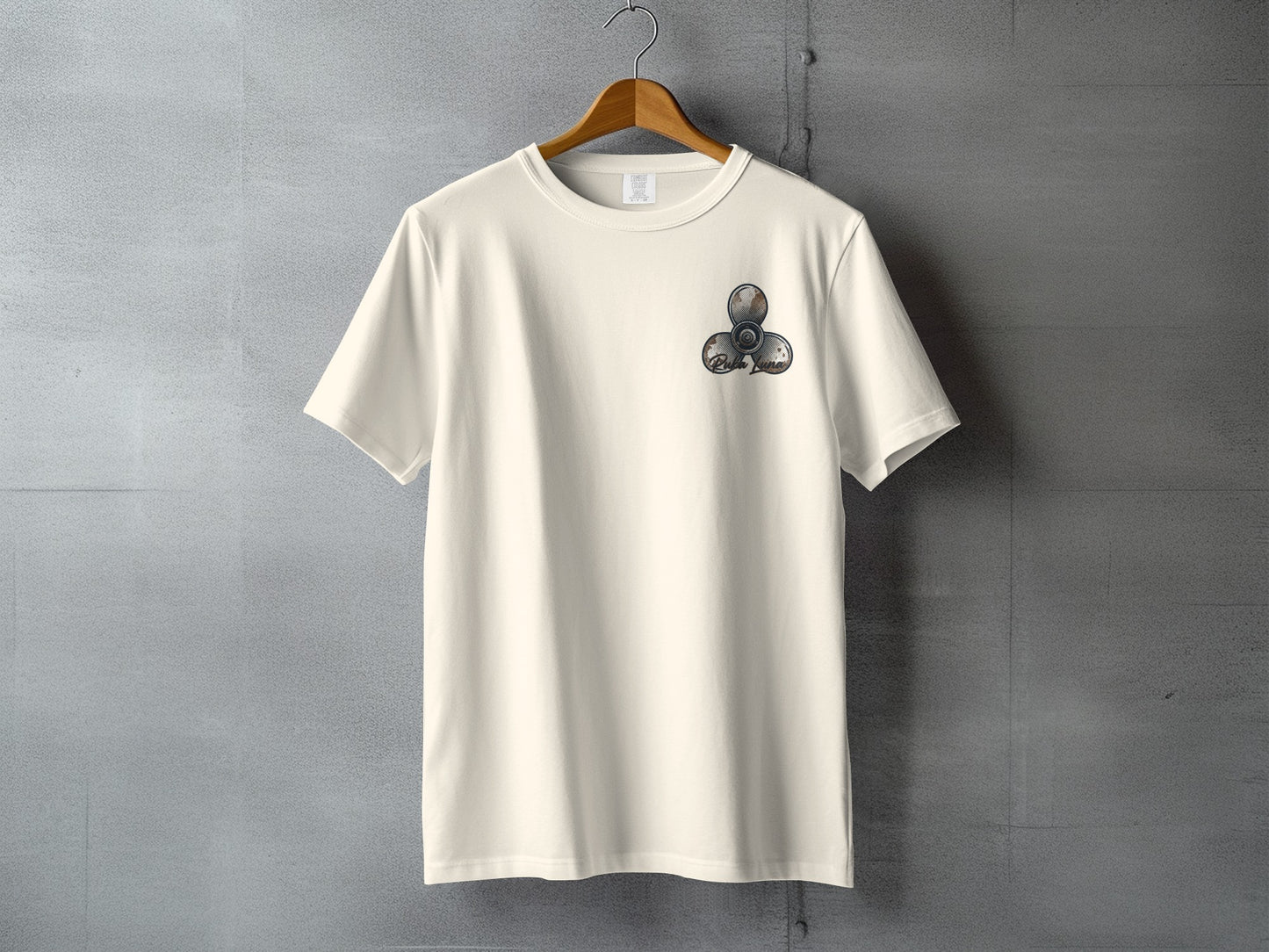 Cream t-shirt with three metallic fidget spinners on chest pocket.