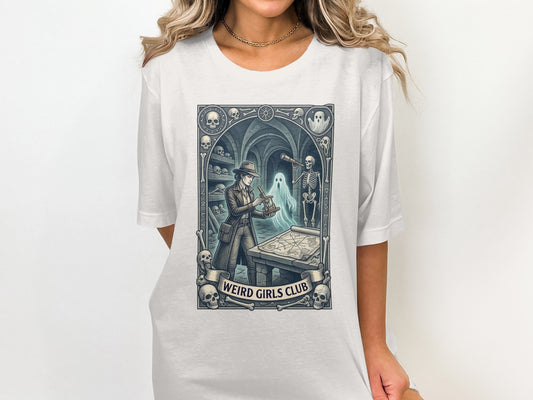 T-shirt graphic: Woman in hat examining map with skeleton and ghost.