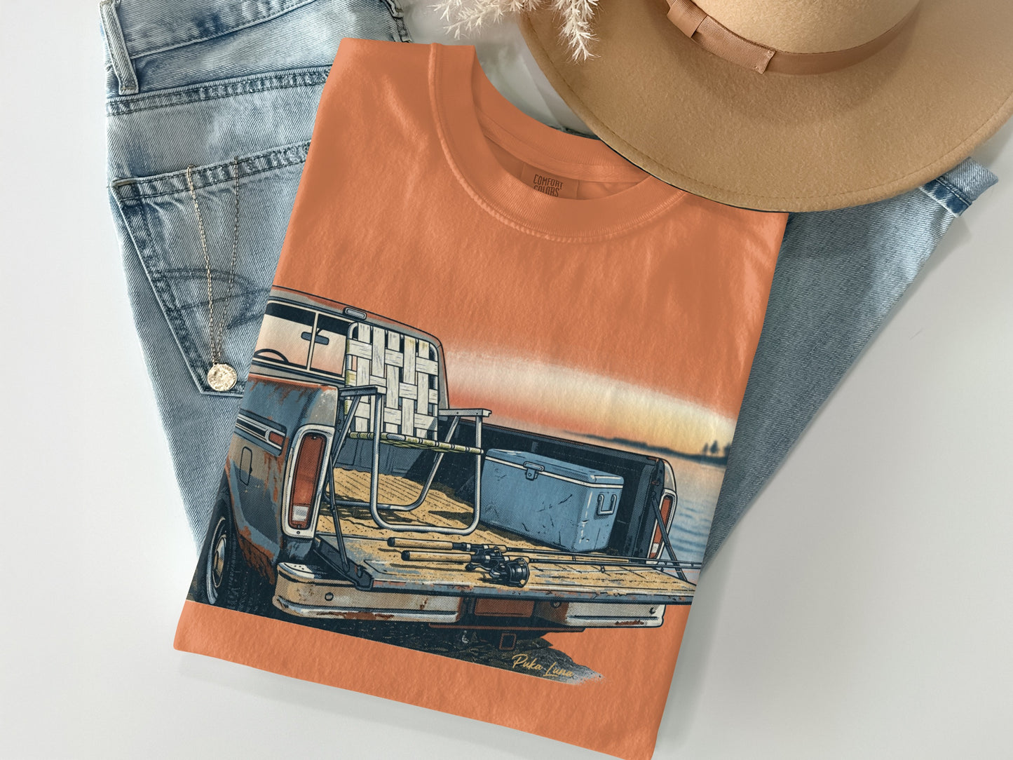 Orange t-shirt with graphic of a vintage pickup truck at sunset.