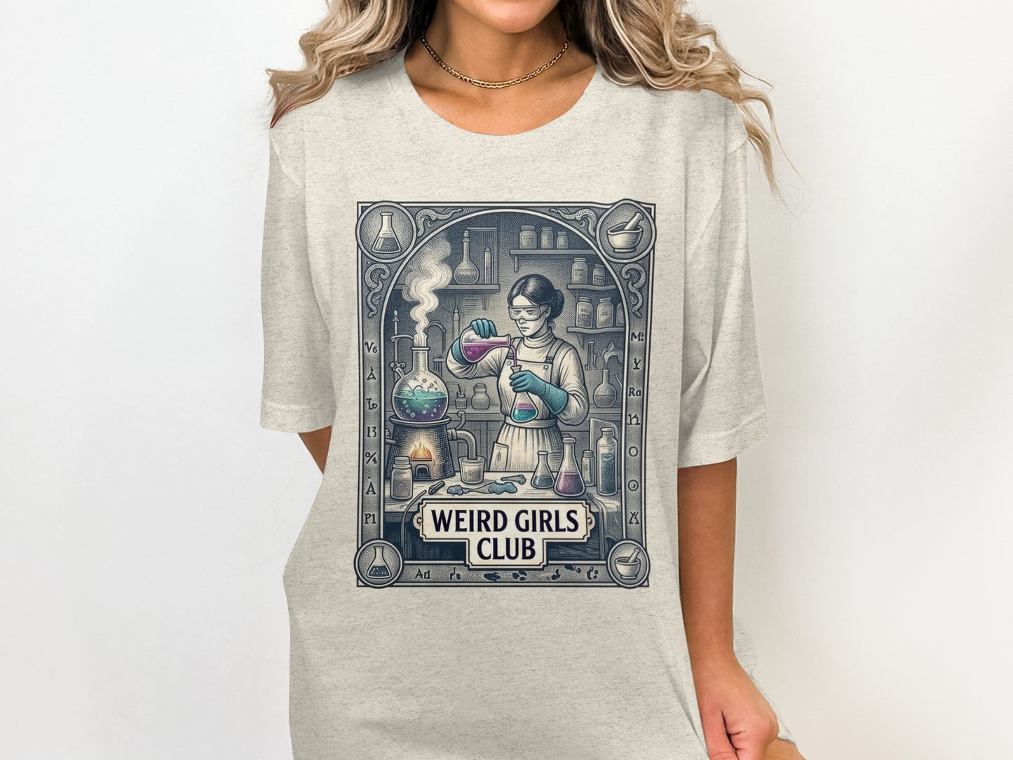 Graphic tee with woman in lab coat performing chemistry experiment, "Weird Girls Club" text.