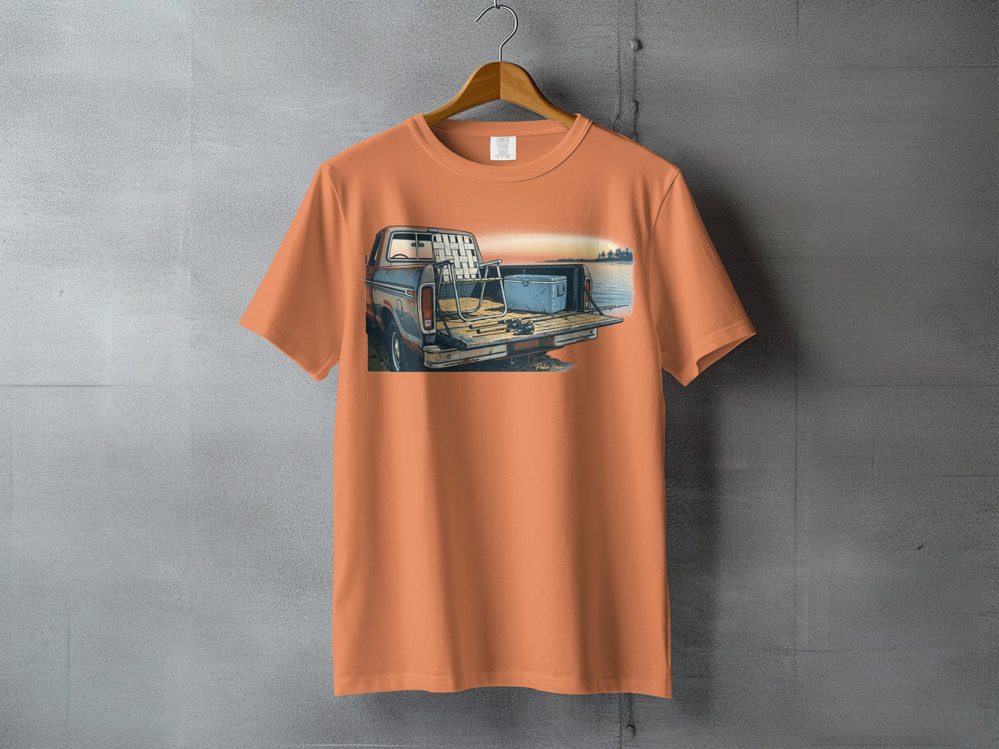 Orange t-shirt with illustration of fishing gear and cooler in truck bed.
