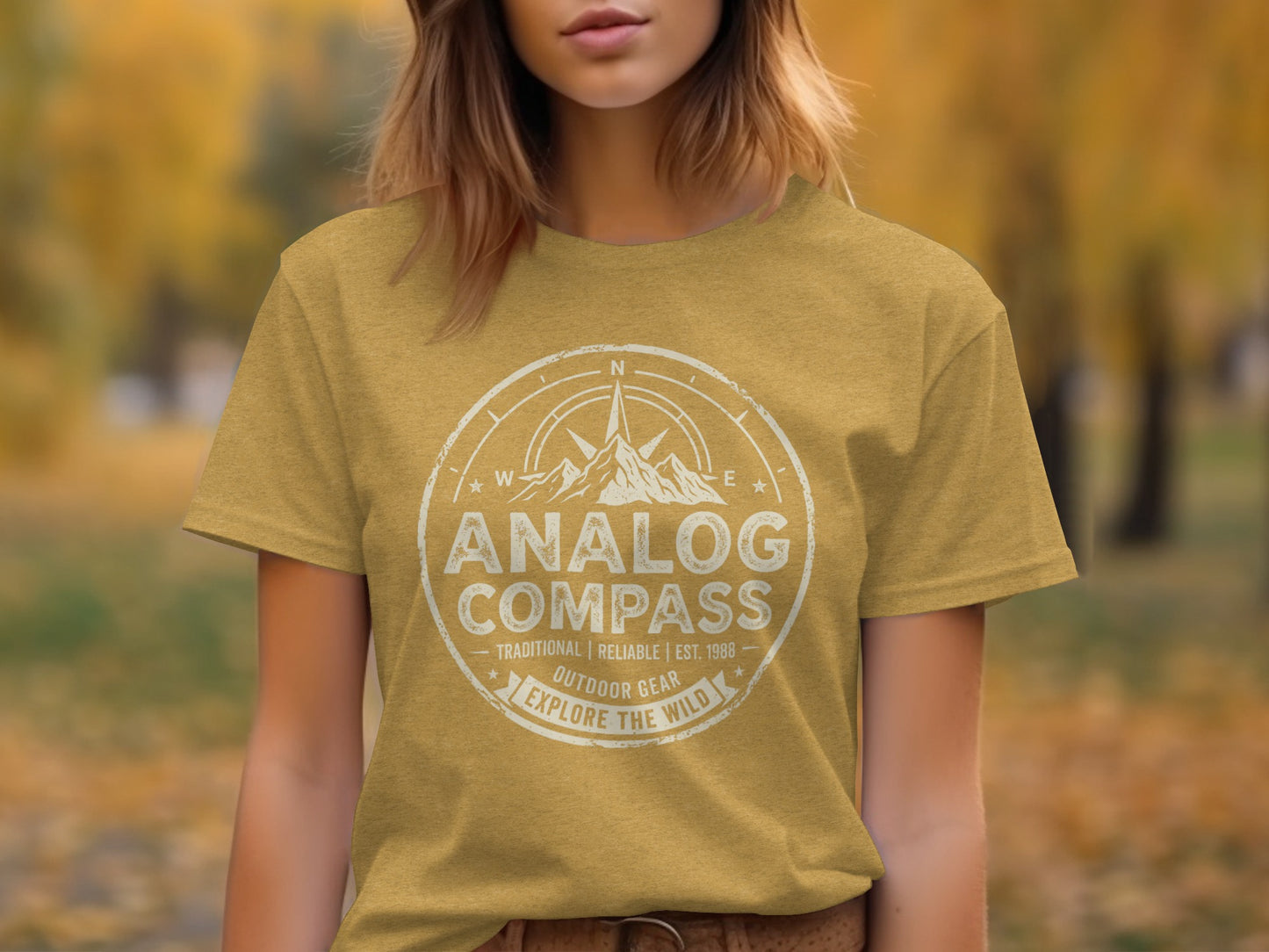 Analog Compass Heritage: The Explorer's Adventure Tee: Yellow t-shirt with "Analog Compass Outdoor Gear Explore The Wild" text.