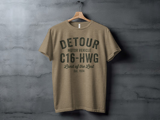 Tan t-shirt with "DETOUR MOTOR VEHICLE C16-HWG Land of the Lost Est. 1974" text.