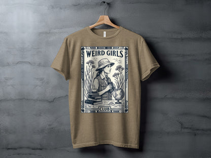 T-shirt graphic of a woman with binoculars, books, and a globe, with "Weird Girls Club" text.