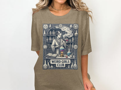 T-shirt graphic of a woman in a lab with beakers and the text "WEIRD GIRLS CLUB".