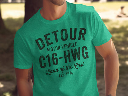 Green t-shirt with black "DETOUR MOTOR VEHICLE C16-HWG Land of the Lost Est. 1974" text.