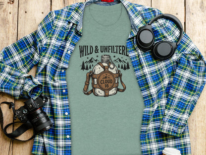 Rugged Wild & Unfiltered Spirit Wilderness Shirt: Green t-shirt with "Wild & Unfiltered Cloud 16" graphic, headphones, and camera.