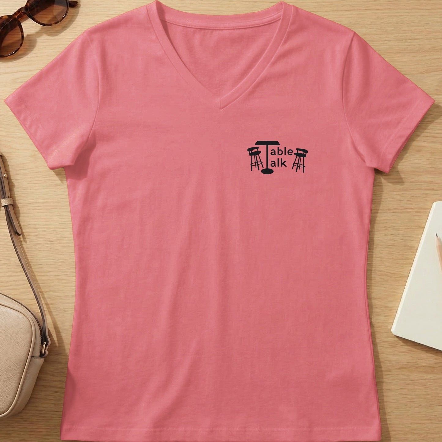 Pink v-neck t-shirt with "Table Talk" logo featuring a table and chairs.