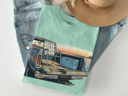 Mint green t-shirt with graphic of vintage truck bed, cooler, and fishing rods.