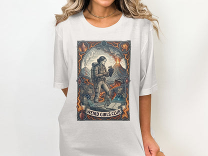 Woman wearing white t-shirt with "Weird Girls Club" graphic featuring a volcano and hiker.