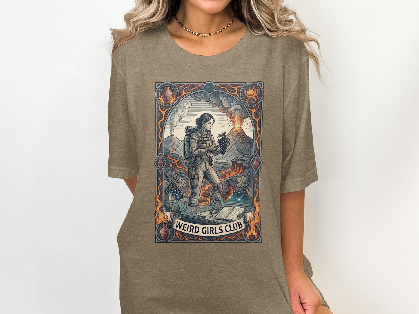 Graphic t-shirt with "Weird Girls Club" text and volcano, grape, and book illustrations.