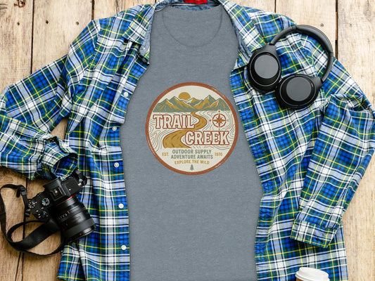Heritage Heritage Explorer Trail Creek Nomad Tee: Gray t-shirt with "Trail Creek Outdoor Supply Adventure Awaits Explore the Wild" graphic.