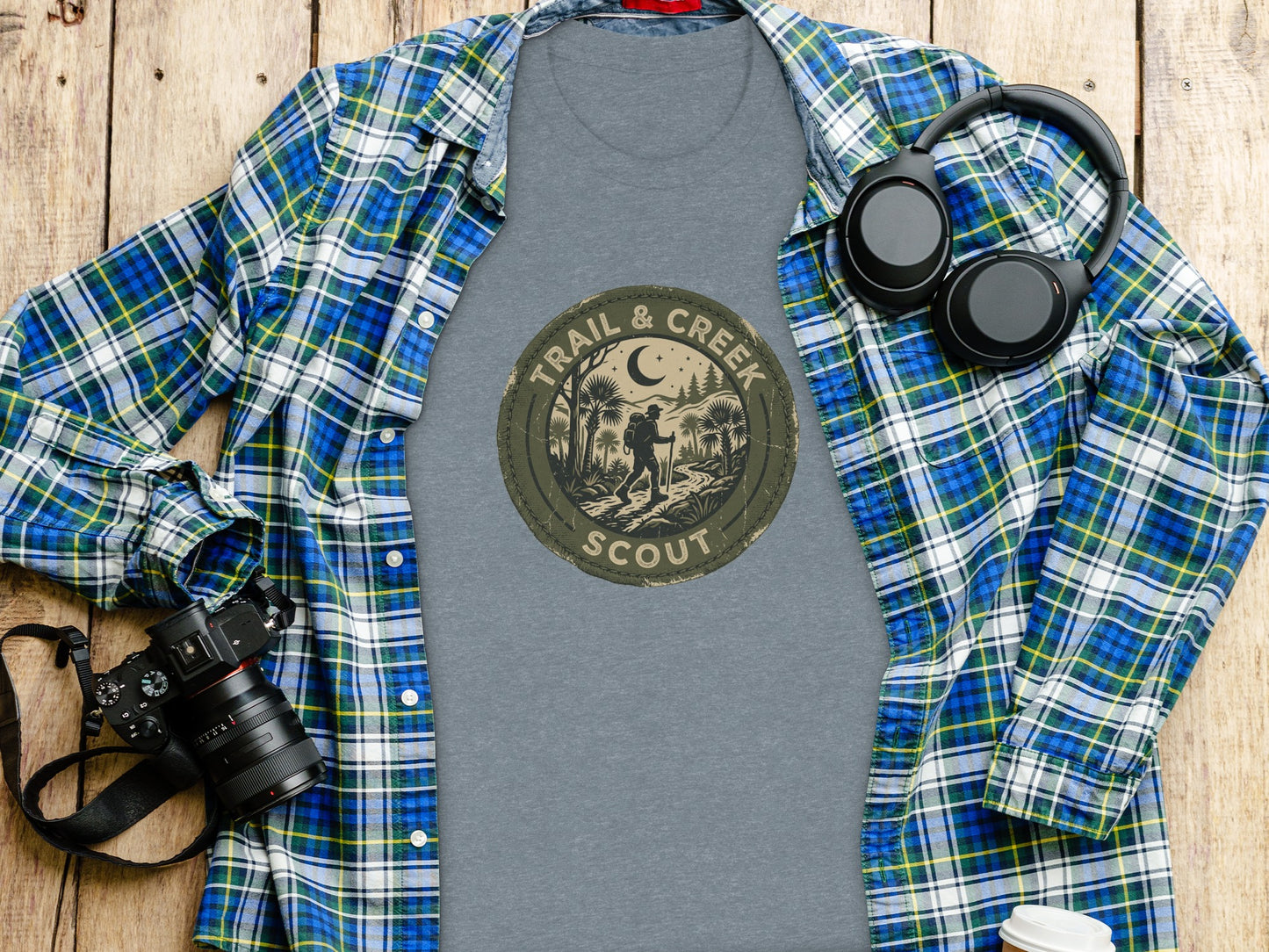 Heritage Trail & Creek Scout Adventure Nomad Tee: T-shirt with "Trail & Creek Scout" logo, laid flat with camera and headphones.