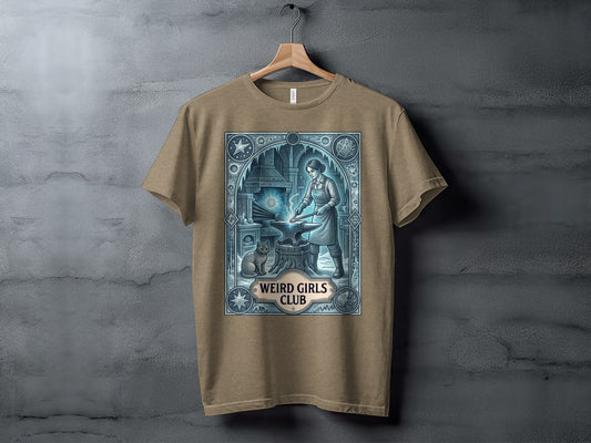 Brown t-shirt with an anvil, blacksmith, cat, and "Weird Girls Club" text.